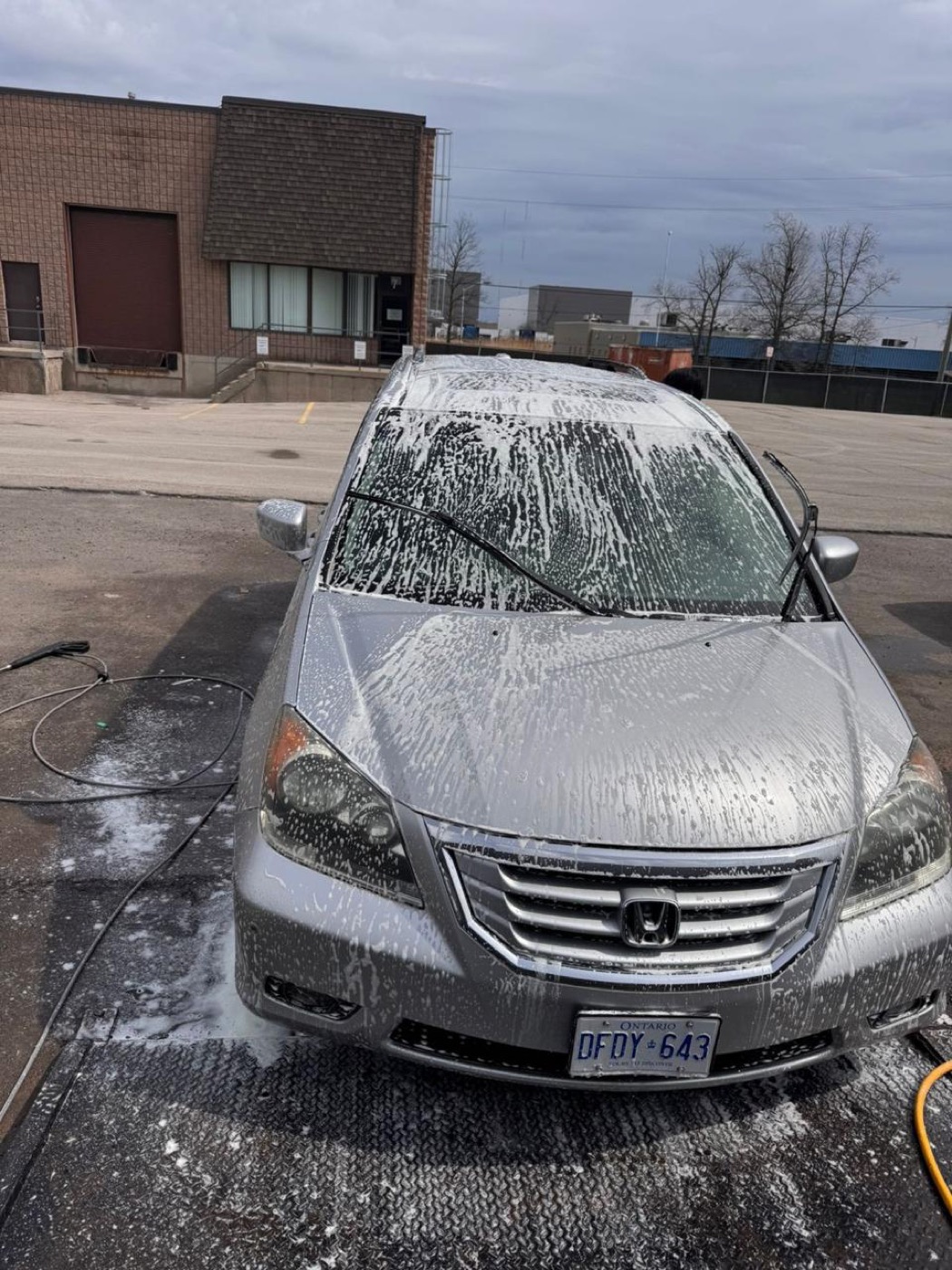 Foam hand wash being applied to a silver minivan in Mississauga